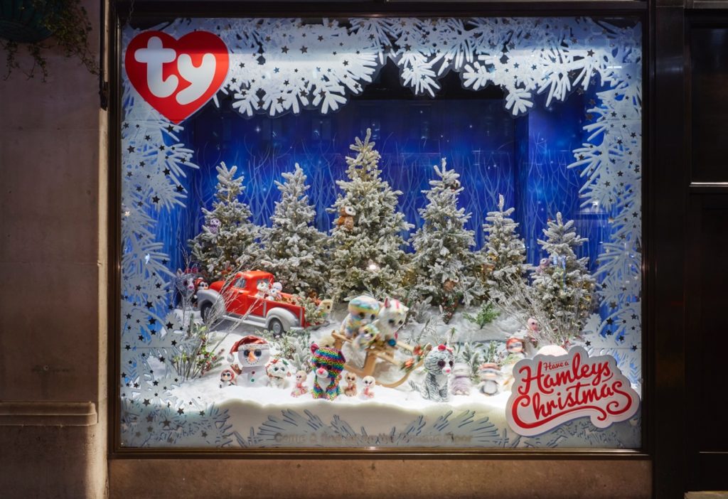 Hamleys Christmas window with trees and other foliage from Flourish Trading including snow berries, twigs and frosted pine cones
